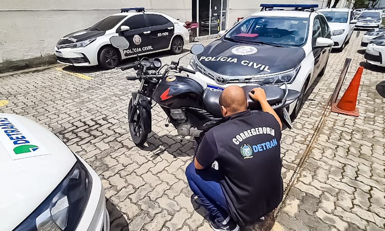 Funcionário do Detran apreendendo a moto clonada na Zona Oeste