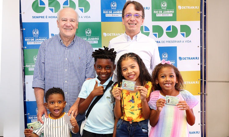 Mini foliões ao lado do Presidente do Detran.RJ mostrando a nova Carteira de Identidade Nacional