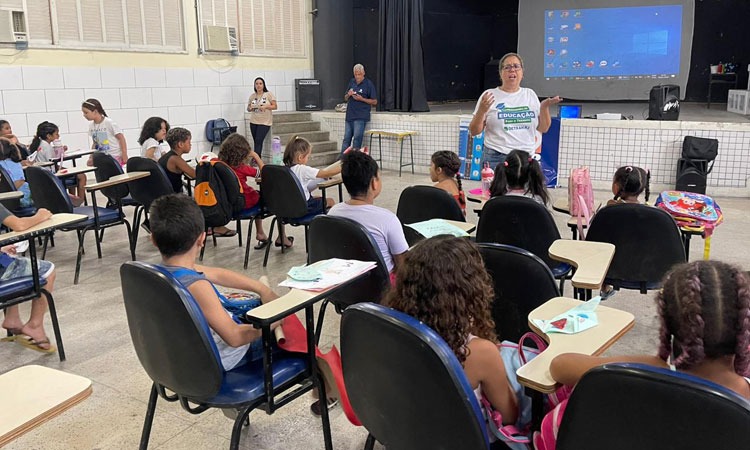 Funcionária de educação do Detran ensina crianças em sala de aula sobre a segurança no transporte público