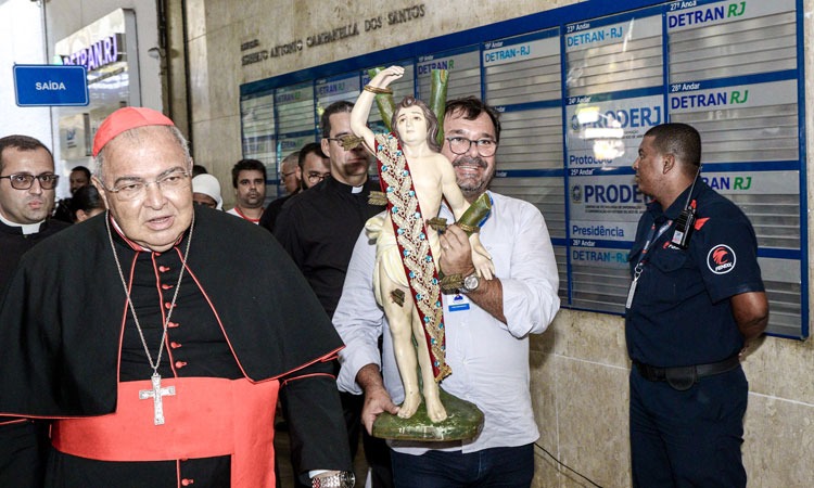 Vice-Presidente do Detran, ao lado do Cardeal Arcebispo do Rio de Janeiro, carrega imagem de São Sebastião no saguão de entrada do Detran.RJ