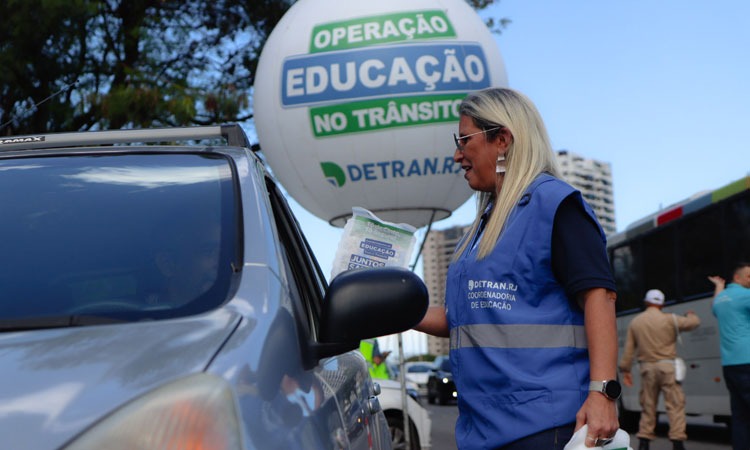 Agente do Detran distribui brindes a motorista em blitz educativa em via pública