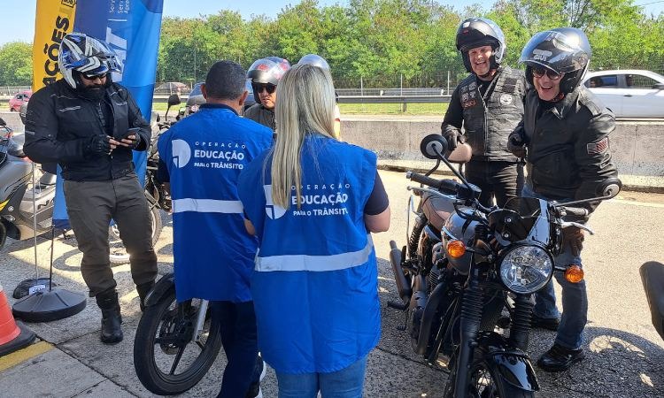 Funcionários do Detran distribuem brindes aos motociclistas na rua