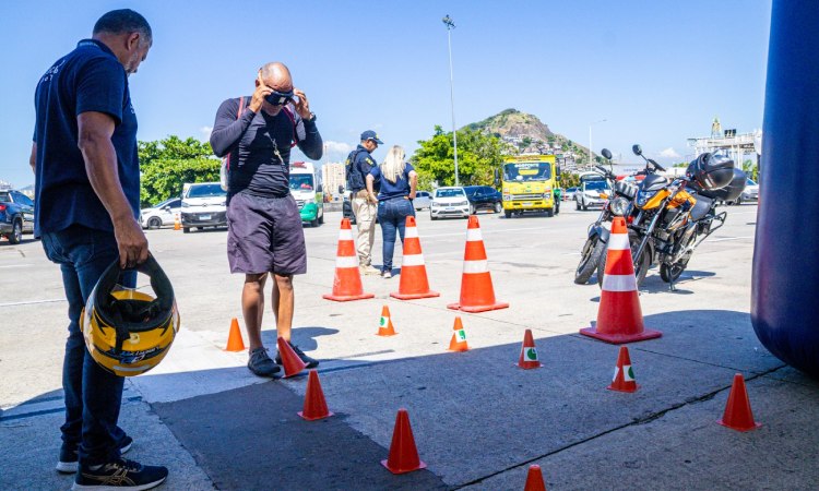 Motociclista faz o teste no circuito de cones usando óculos que simulam efeito de drogas, álcool e sono