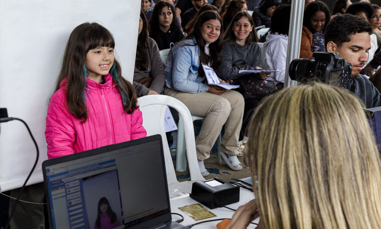 Menina faz pose para foto ao tirar carteira de identidade no Detran Presente 